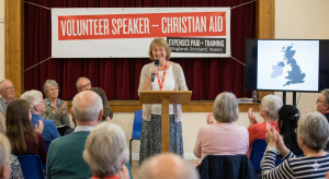 A professional volunteer speaker for Christian Aid presenting to a community group
